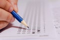 Students hand holding pencil writing selected choice on answer sheets and Mathematics question sheets. students testing doing Royalty Free Stock Photo