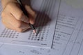 Students hand holding pencil writing selected choice on answer sheets and Mathematics question sheets. students testing doing Royalty Free Stock Photo