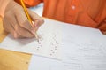 Students hands taking exams, writing examination room with holding pencil on optical form of standardized test with answers and e Royalty Free Stock Photo