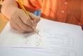 Students hands taking exams, writing examination room with holding pencil on optical form of standardized test with answers and e Royalty Free Stock Photo