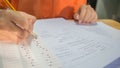 Students hands taking exams, writing examination room with holding pencil on optical form of standardized test with answers and e Royalty Free Stock Photo