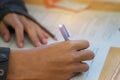 Students hands taking exams, writing examination room with holding pencil on optical form of standardized test with answers and e Royalty Free Stock Photo