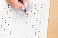 Student hand testing in exercise and passing exam carbon paper computer sheet with pencil in school test room, education concept Royalty Free Stock Photo