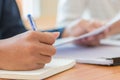 Students holding pen in hands taking exams, writing examination room with undergraduate students inside. Student sitting learning. Royalty Free Stock Photo