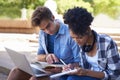 Students, laptop and teamwork on campus for education or online project, research or studying. Man, woman and notebook