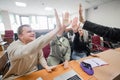 Students and lecturer give a high five in the university classroom. Royalty Free Stock Photo