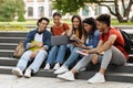 Students Leisure. Group of multiethnic college friends resting in campus outdoors Royalty Free Stock Photo