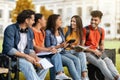 Students Leisure. Happy Multiethnic College Friends Relaxing Together Outdoors After Classes Royalty Free Stock Photo
