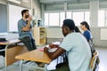 Students listening to male teacher in classroom Royalty Free Stock Photo