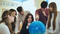 Students look at a globe of the starry sky in a classroom at school.