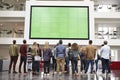 Students looking up at a big screen in university building Royalty Free Stock Photo