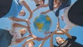 Students make a circle around the globe of the world. The concept of world peace.