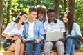 Students Passtime. College Friends Sitting Outdoors With Laptop, Watching Videos Together