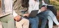 Students preparing group project, sitting on bench in park Royalty Free Stock Photo