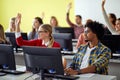 Students raising hands for an answer on professor question at an informatics lecture. Smart young people study at the college. Royalty Free Stock Photo