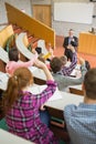 Students raising hands with a teacher in the lecture hall Royalty Free Stock Photo