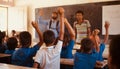 Students raising their hands in a classroom Royalty Free Stock Photo