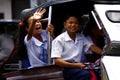 Students ride a tricycle on their way to school.