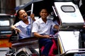 Students ride a tricycle on their way to school.