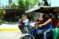 Students riding a tricycle to get to school