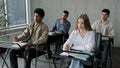 Students sit at desk in classroom attentive listen lecture at seminar write notes prepare for exam business audience at Royalty Free Stock Photo