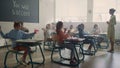 Students sitting at desks in classroom. Pupils playing with paper planes Royalty Free Stock Photo