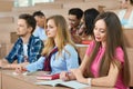 Students sitting on wooden desks in classroom.