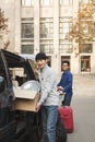 Students smiling and moving into dormitory on college campus