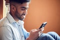 Students and social media go hand in hand. a young man using a smartphone in a library at university. Royalty Free Stock Photo