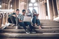 Students are spending time together.Multiethnic group of young people looking at a laptop and and sitting on steps in university Royalty Free Stock Photo