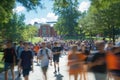 Students strolling through a vibrant college campus on a sunny day with motion blur effect Royalty Free Stock Photo
