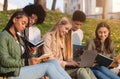 Students studying hard, sitting on the ground at park Royalty Free Stock Photo