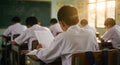 Students Taking Exam in Classroom with Natural Sunlight Education Royalty Free Stock Photo