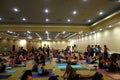 Students talk and gather before the start of large yoga class fe