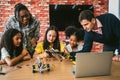 Students with a teacher build a robotic arm in a classroom, collaborating around a laptop and electronics during a STEM workshop Royalty Free Stock Photo