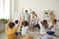 Happy school students with teacher playing games and having fun in the classroom