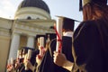 Degree diploma certificate in hand of graduates standing in line rear view