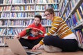 the students uses a notebook, laptop and a school library Royalty Free Stock Photo