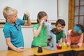 Students using science beakers and a microscope