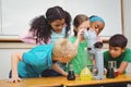 Students using science beakers and a microscope Royalty Free Stock Photo