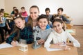 Students using science beakers and a microscope at the elementary school.