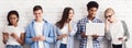 Students with various gadgets and laptop against white wall Royalty Free Stock Photo