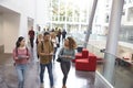 Students walk and talk using mobile devices in university Royalty Free Stock Photo