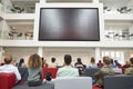 Students watching big screen in university atrium, back view Royalty Free Stock Photo