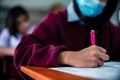 Students wearing mask for protect corona virus or covid-19 and doing exam in classroom with stress Royalty Free Stock Photo