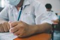 Students wearing mask for protect corona virus or covid-19 and doing exam in classroom with stress Royalty Free Stock Photo