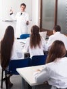 Students in white coats listen to lecture in audience Royalty Free Stock Photo