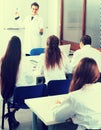 Students in white coats listen to lecture in audience Royalty Free Stock Photo