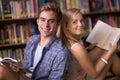 Students, woman and man with books, portrait and smile for learning, scholarship or studying in college library. People Royalty Free Stock Photo
