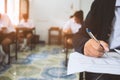 Students writing and reading exam answer sheets exercises in classroom of school with stress Royalty Free Stock Photo